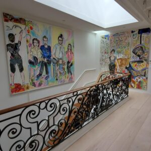 Hallway with painting of family and stair railing