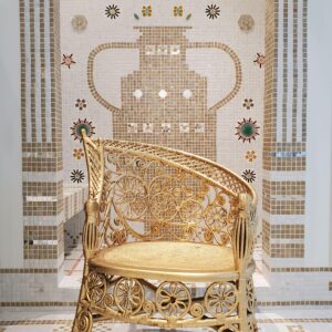 Gold wicker chair by fresco wall
